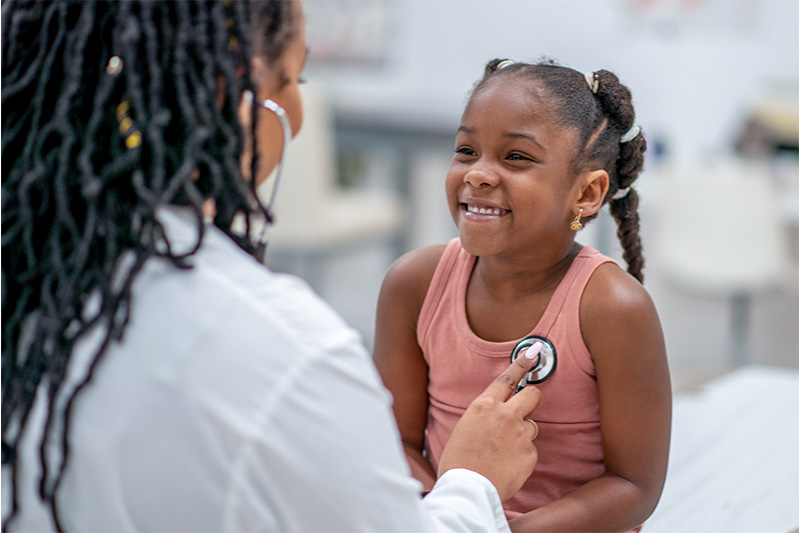 Picture of a child getting her vitals checked by a doctor.