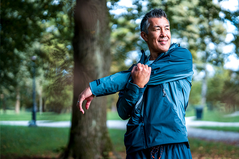Man in track suit stretching after running.